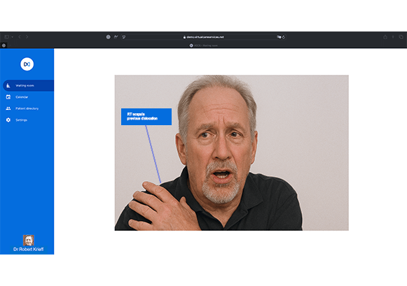 A guy on a telehealth call holding his shoulder