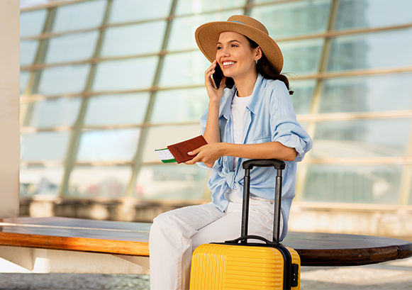 smiling woman with a suitcase and a passport at the airport
