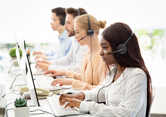 Women with headsets in front of monitors